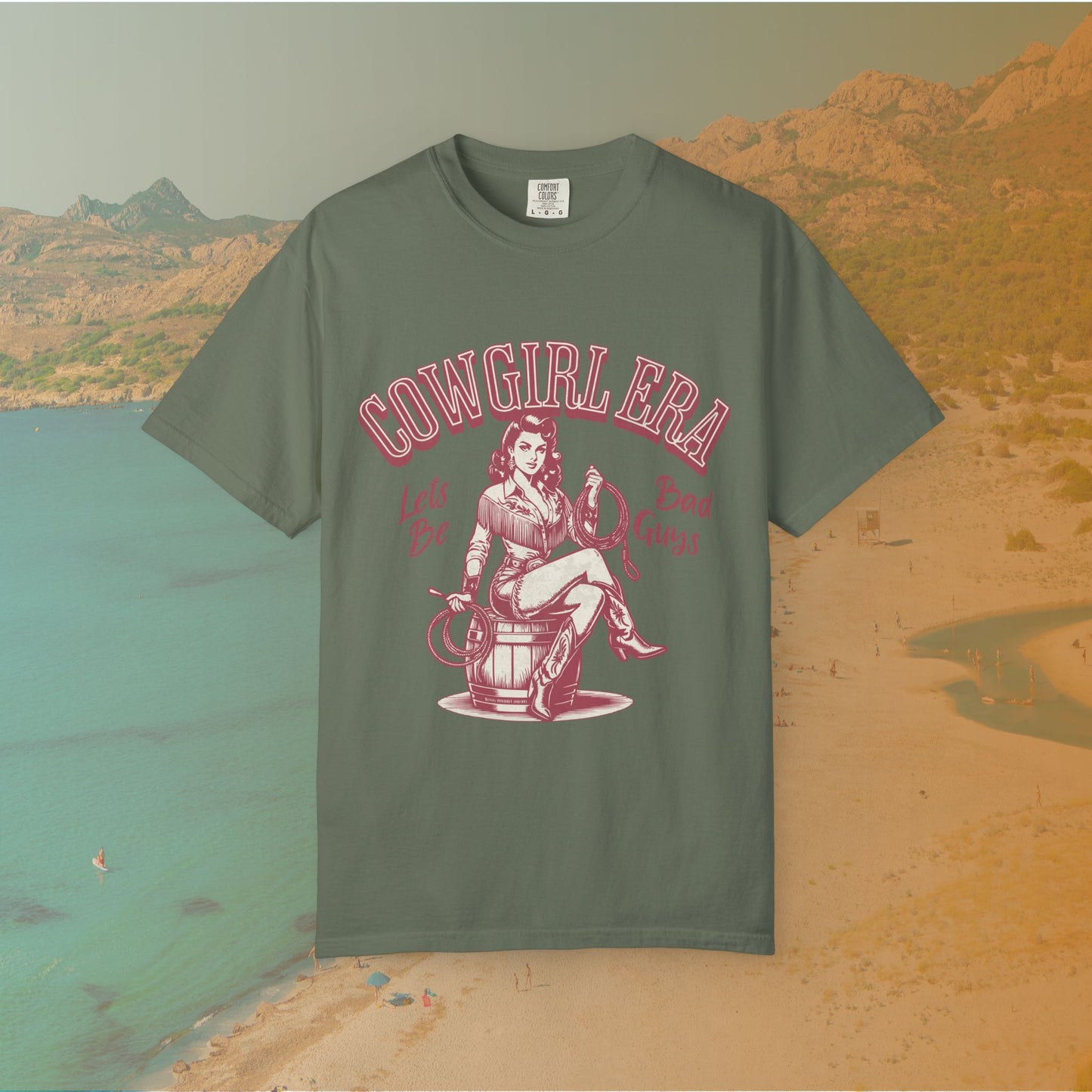 Cowgirl Era pinup T-shirt with a vintage-style illustration of a sassy cowgirl sitting on a barrel holding a lasso. The graphic includes the text "COWGIRL ERA" and "Lets Be Bad Guys.