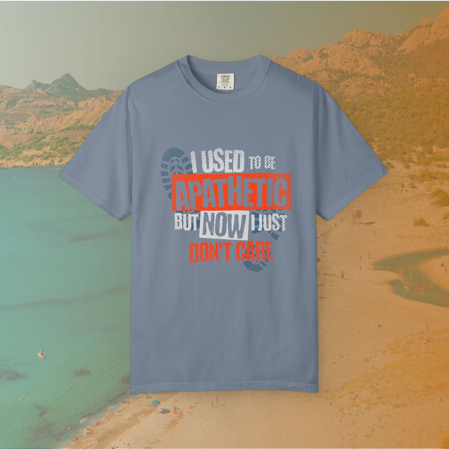 blue Graphic T-shirt featuring the layered, distressed text: "I USED TO BE APATHETIC BUT NOW I JUST DON'T CARE," overlaid with halftone dot textures and boot print graphics.