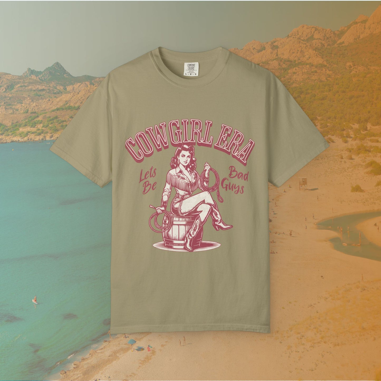 Cowgirl Era pinup T-shirt with a vintage-style illustration of a sassy cowgirl sitting on a barrel holding a lasso. The graphic includes the text "COWGIRL ERA" and "Lets Be Bad Guys.