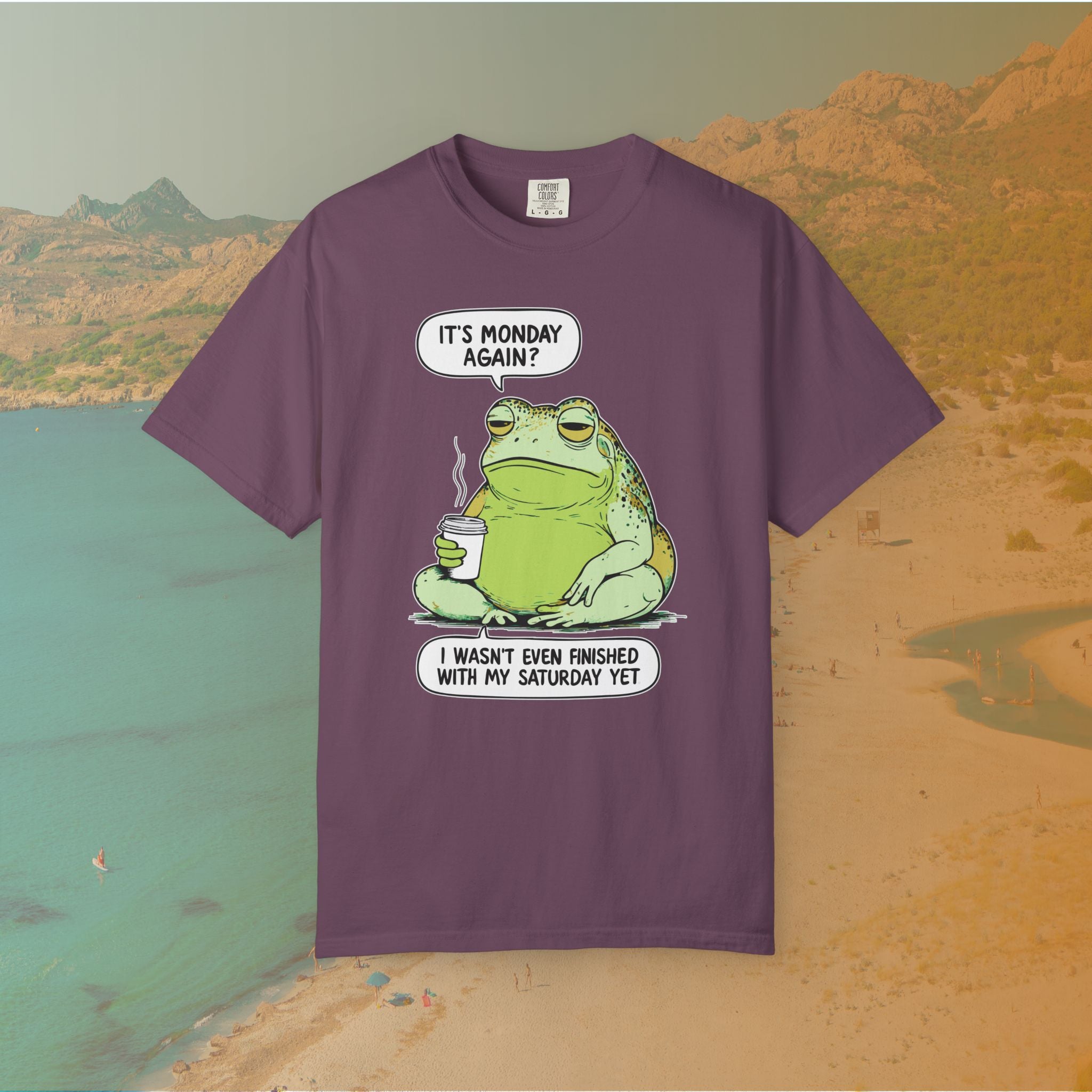 purple t-shirt Funny T-shirt graphic featuring a large, grumpy toad holding a to-go coffee cup. The cartoon is captioned with the quotes: "IT'S MONDAY AGAIN? I WASN'T EVEN FINISHED WITH MY SATURDAY YET.
