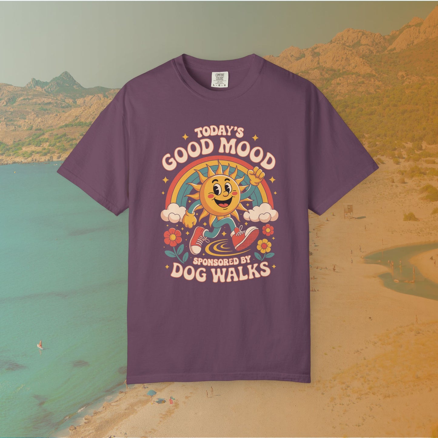 purple  t-shirt Retro 70s-style graphic t-shirt featuring a running, happy cartoon sun in sneakers under a rainbow and clouds. The slogan reads: "TODAY'S GOOD MOOD SPONSORED BY DOG WALKS."