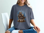 Bear sitting in a camping chair holding a cup by a forest of blue pine trees.