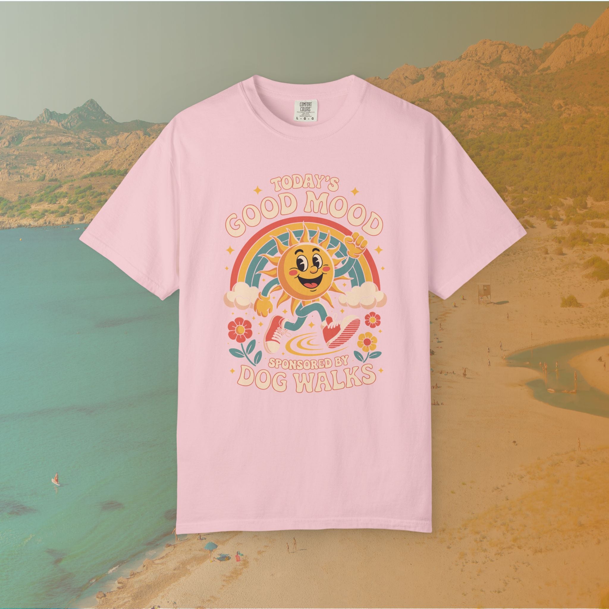 pink  t-shirt Retro 70s-style graphic t-shirt featuring a running, happy cartoon sun in sneakers under a rainbow and clouds. The slogan reads: "TODAY'S GOOD MOOD SPONSORED BY DOG WALKS."