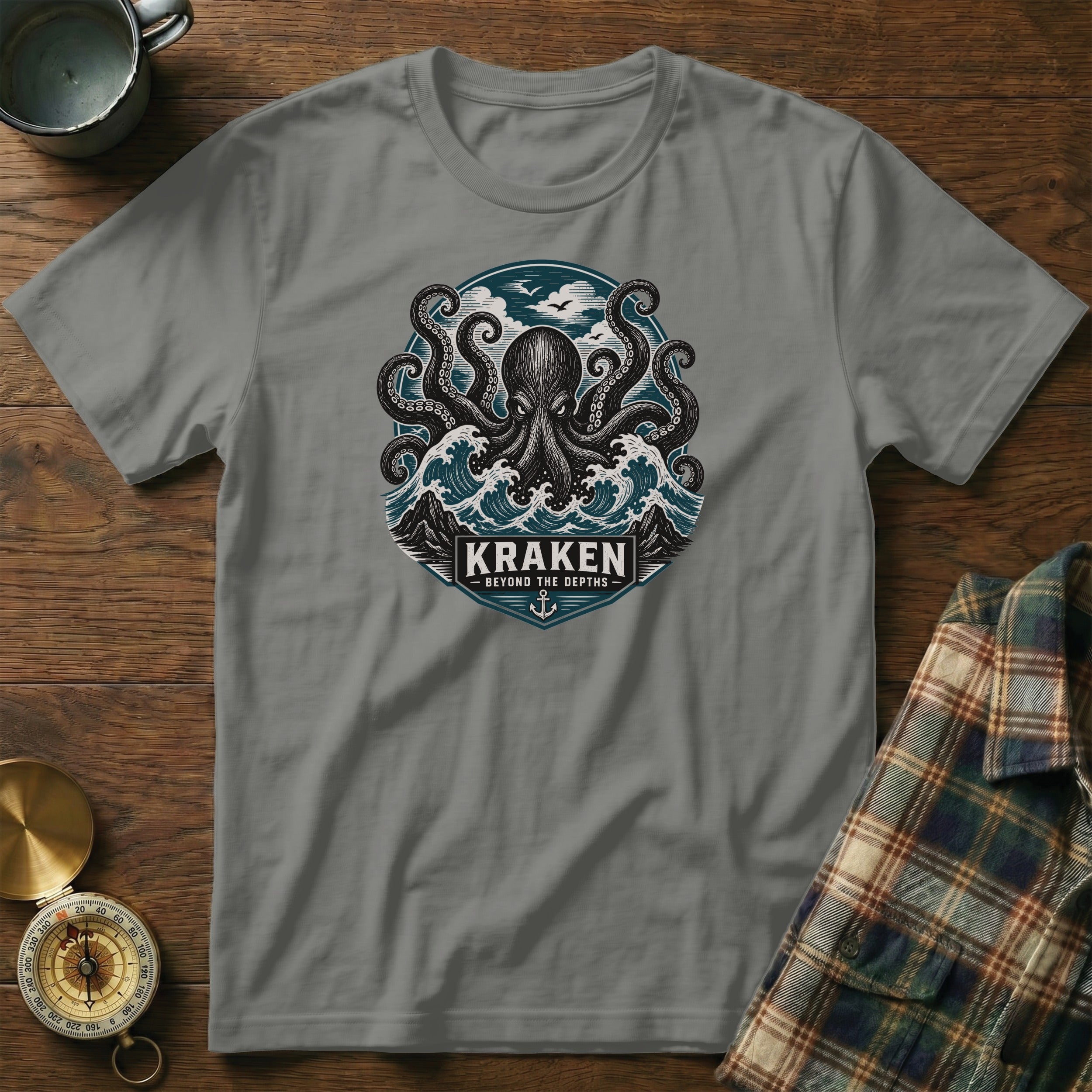Grey t-shirt featuring a kraken and waves graphic with text "KRAKEN BEYOND THE DEPTHS".