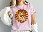 Pink t-shirt with a retro "Smokin' Hot" sun graphic and crossed arms.