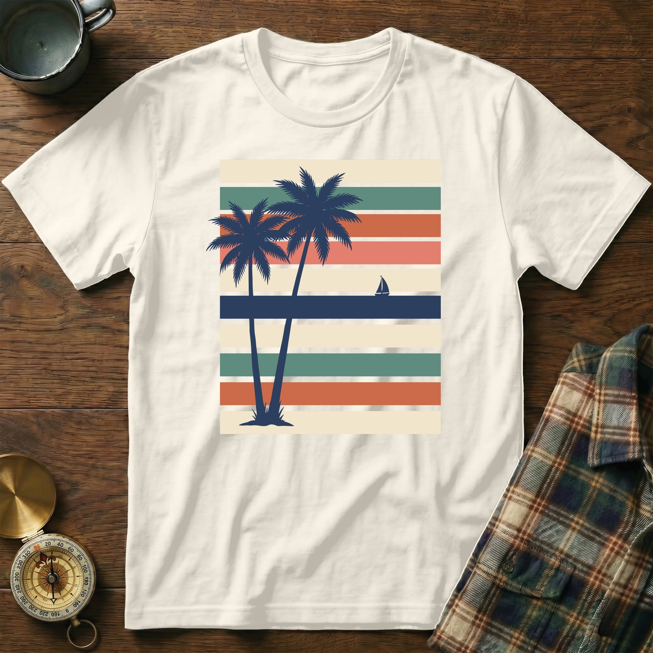 T-shirt with palm trees and sailboat on striped background.