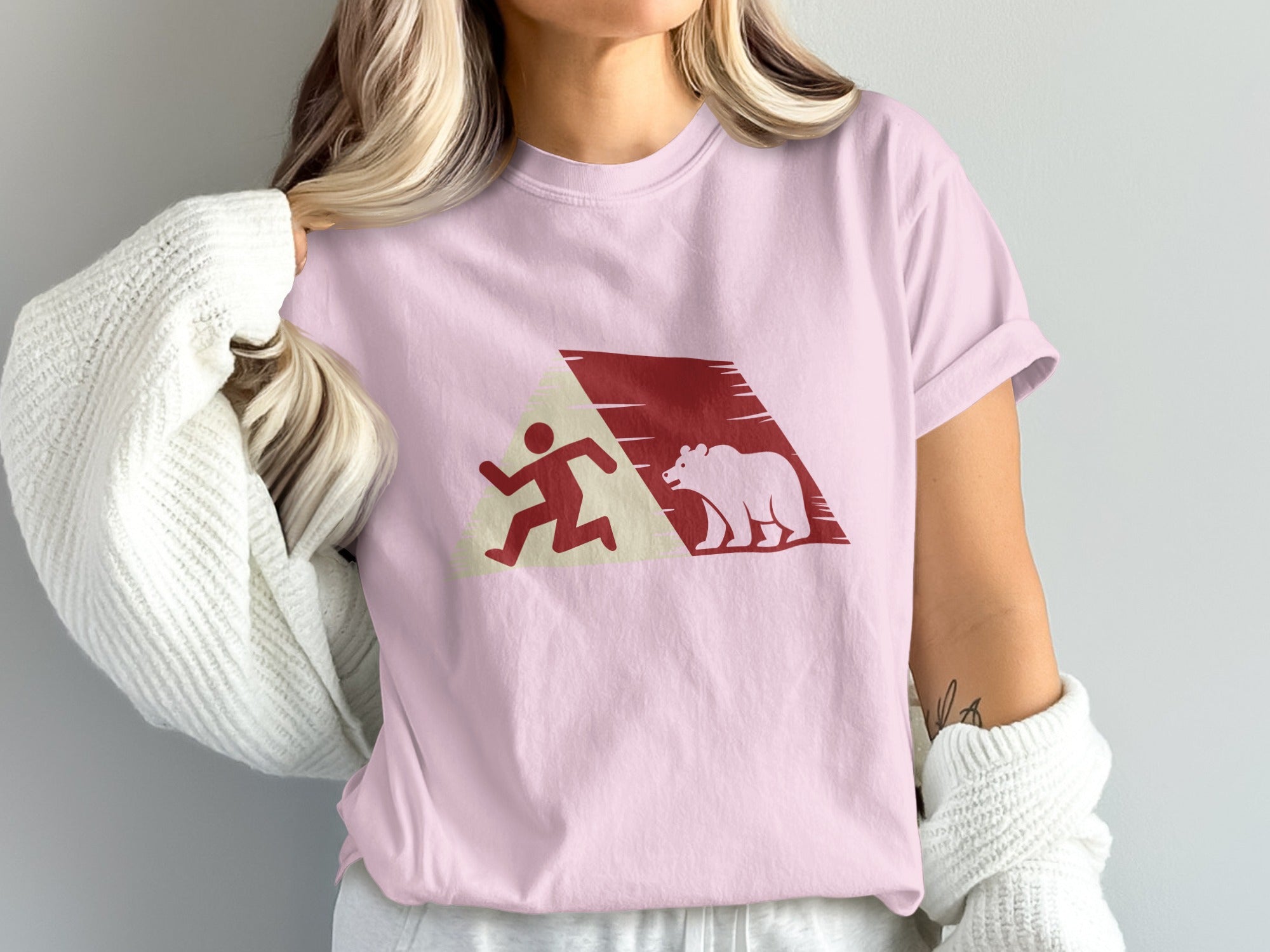 Pink t-shirt with a running figure and bear graphic in red.