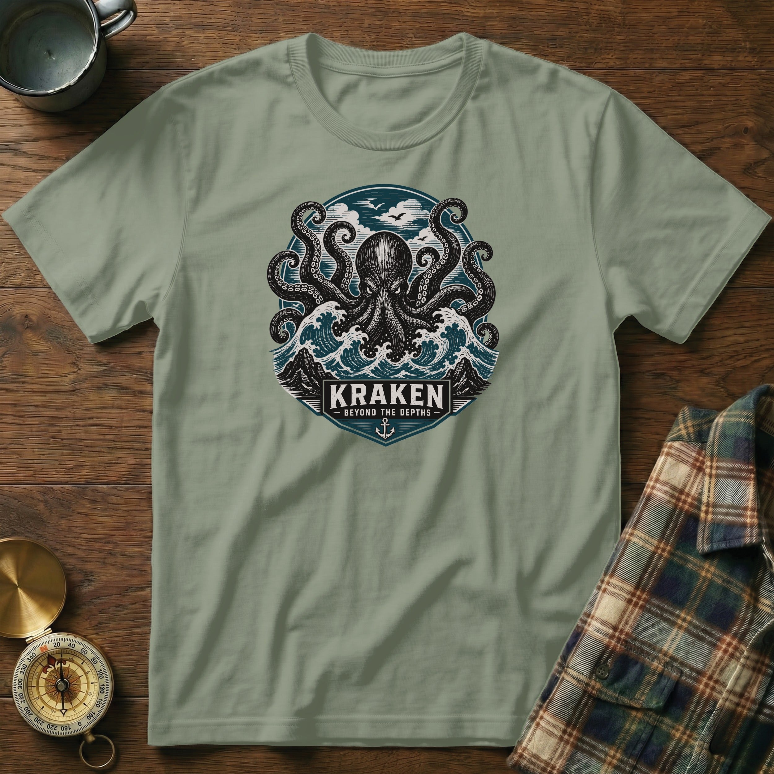 Green t-shirt with Kraken octopus design, waves, mountains, and text.