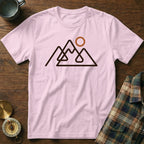 Pink t-shirt with a minimalist mountain range and sun graphic design.