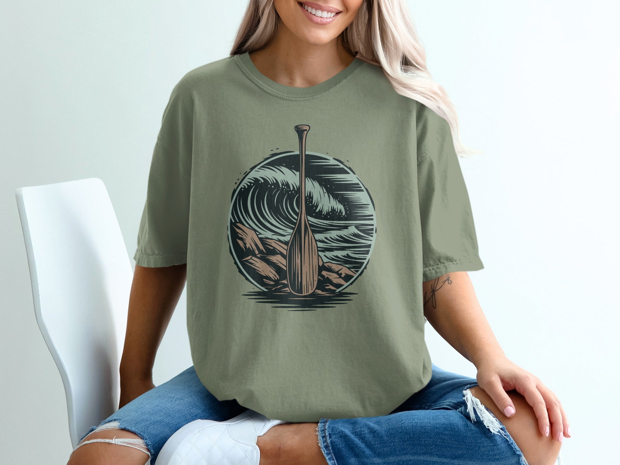 T-shirt with a graphic of a wooden oar and a crashing wave.