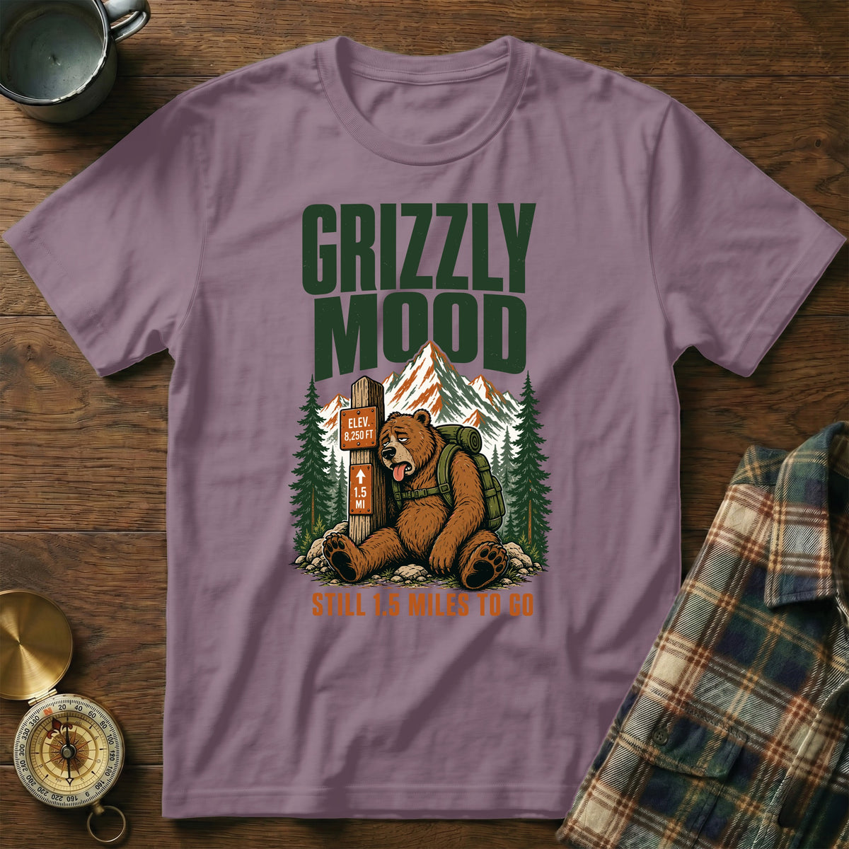 T-shirt graphic of a tired bear sitting by a trail marker that reads "GRIZZLY MOOD" and "STILL 1.5 MILES TO GO."