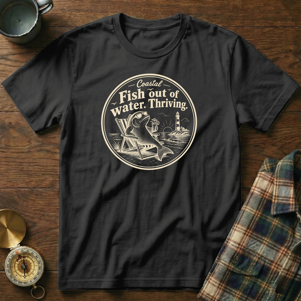 A black t-shirt features a circular graphic of a fish wearing sunglasses lounging on a beach chair.