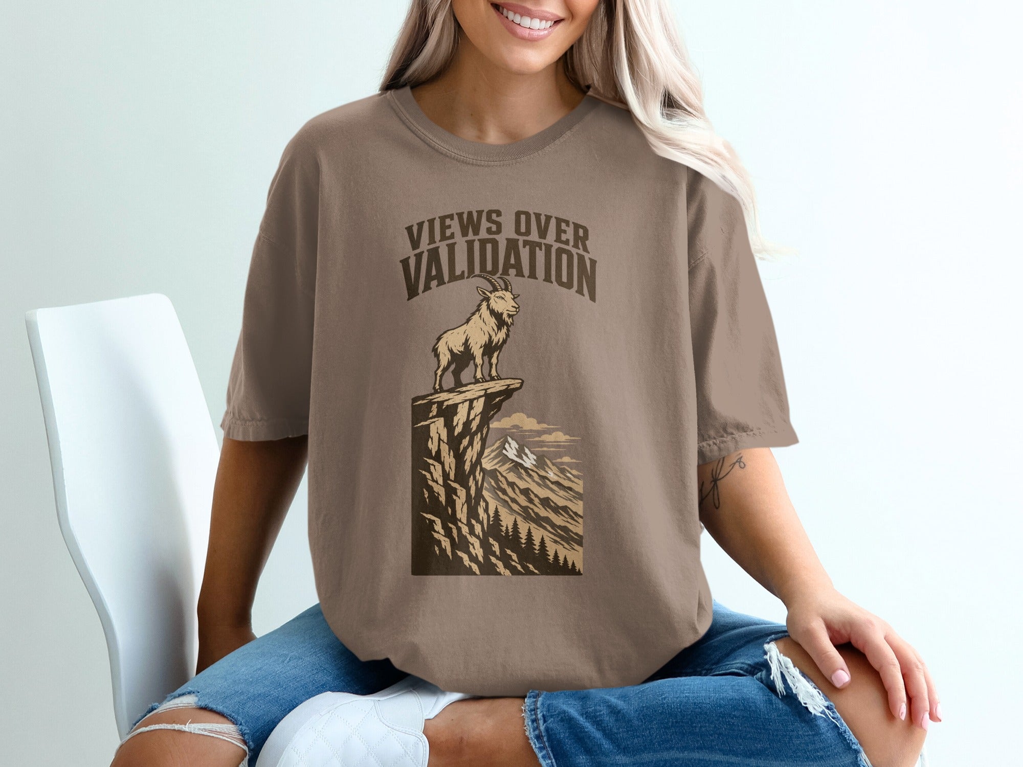 Brown t-shirt with "Views Over Validation" text and a goat on a cliff.