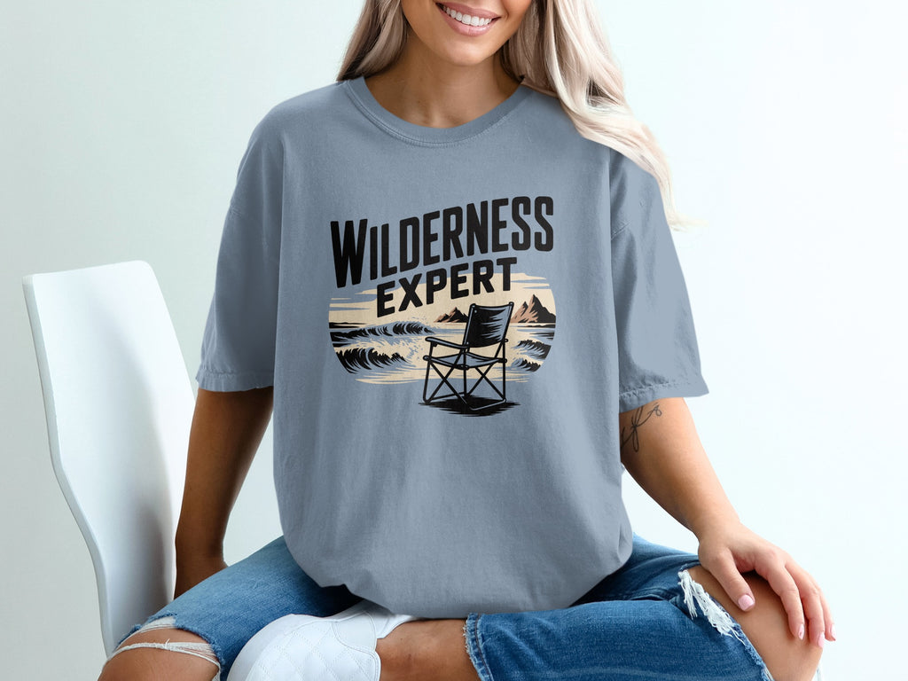 Light blue t-shirt with "Wilderness Expert" text and beach chair graphic.