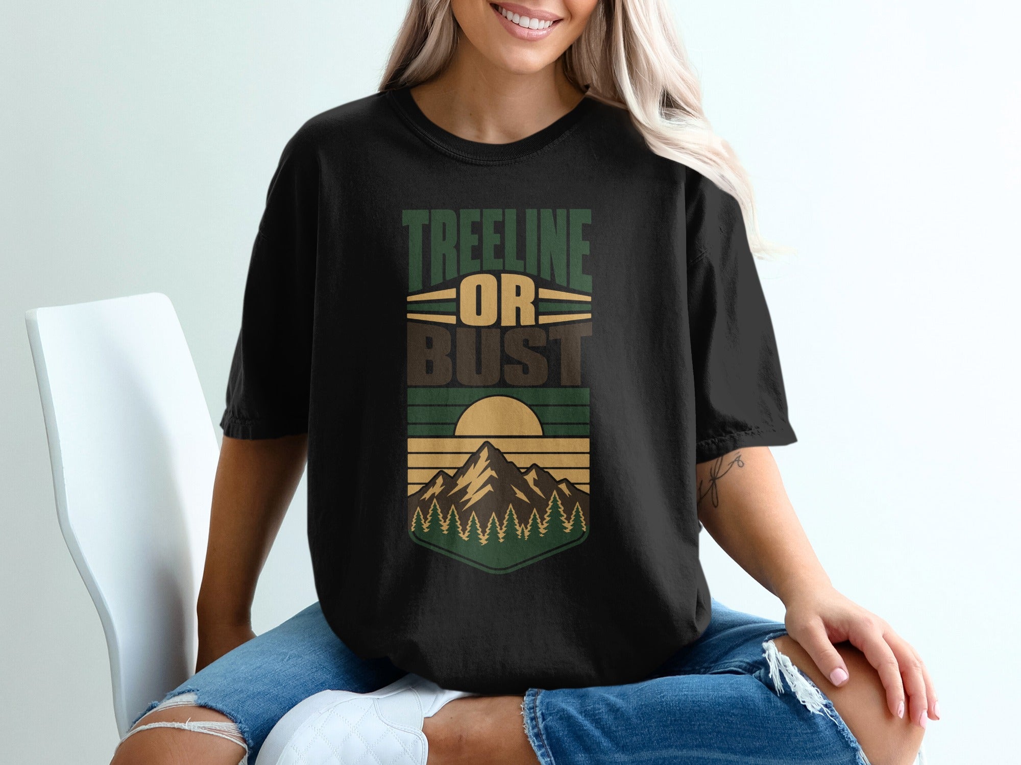 Black t-shirt with "TREELINE OR BUST" text and mountain sunset graphic.