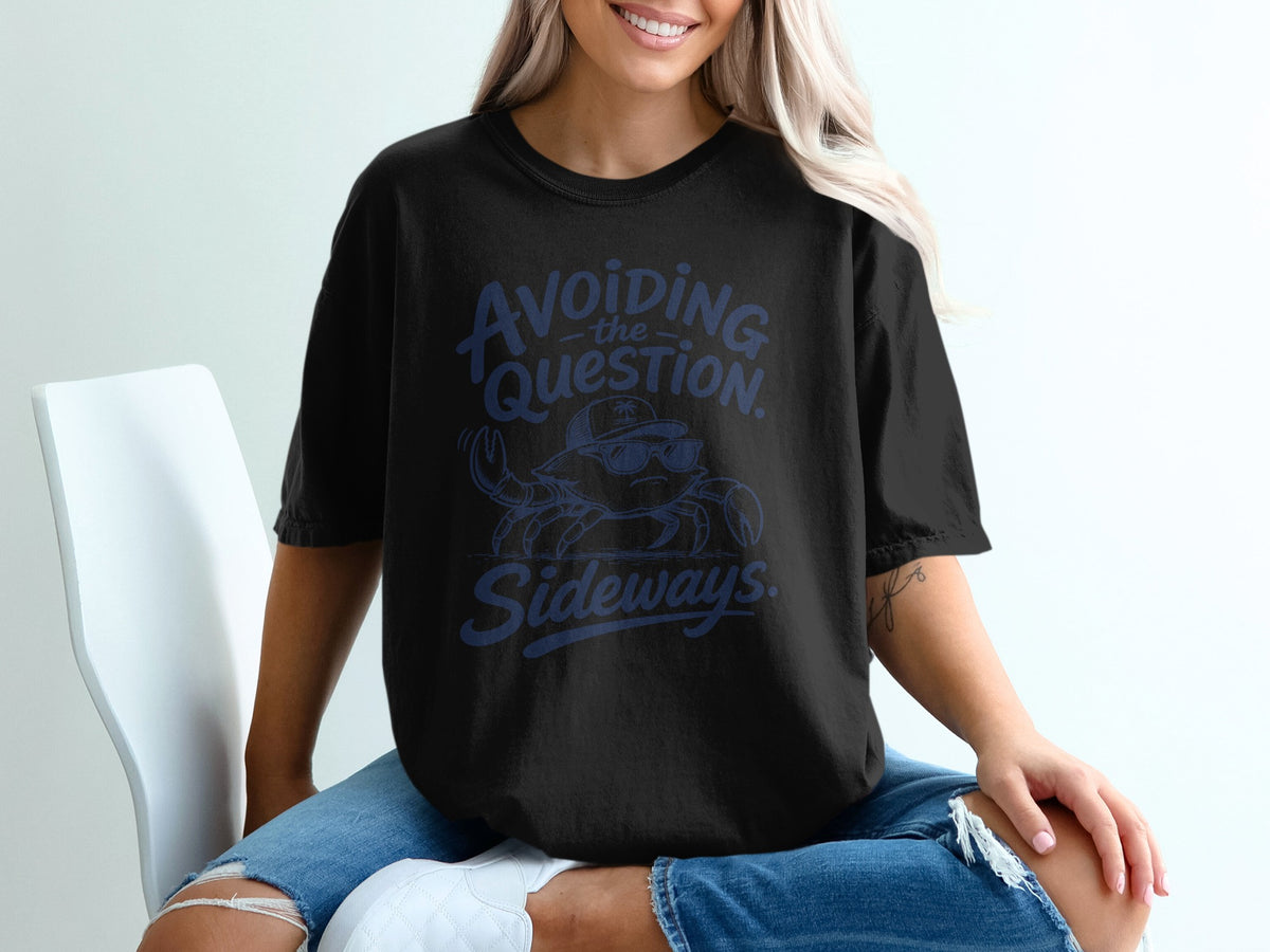 A blonde woman wearing a black t-shirt featuring a crab graphic and text reading Avoiding the Question Sideways.