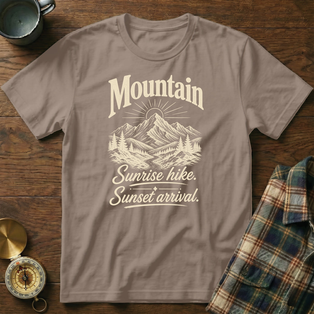 Brown crewneck t-shirt with a vintage mountain landscape graphic and text reading Mountain Sunrise hike. Sunset arrival.