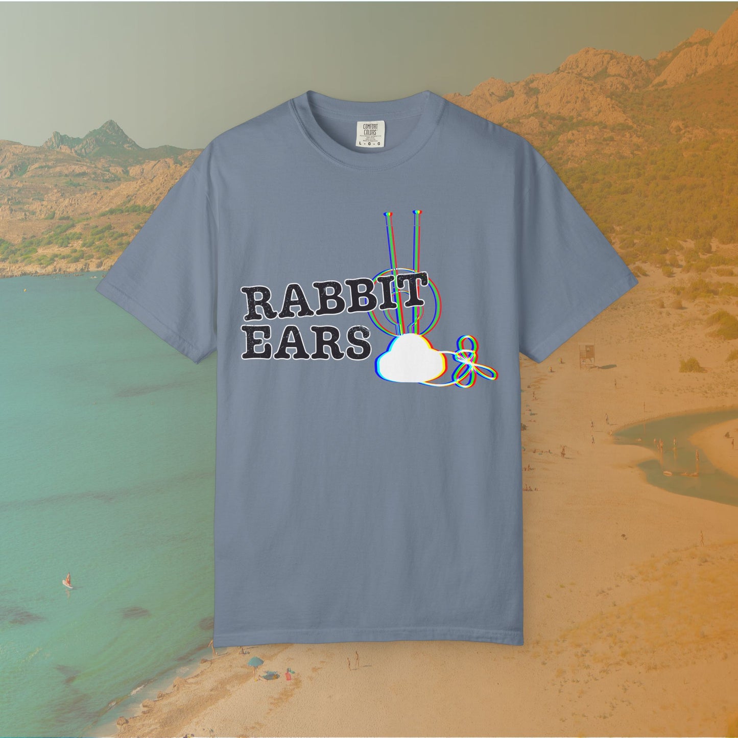 blue t-shirt distressed EDM music festival text "RABBIT EARS" next to a graphic of a vintage TV antenna and cloud shape with a red, green, and blue (RGB) chromatic aberration/glitch effect, with an RGB shift design