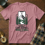Pink t-shirt with mountain, trees, and river graphic and text "Less Scroll. More Stroll."