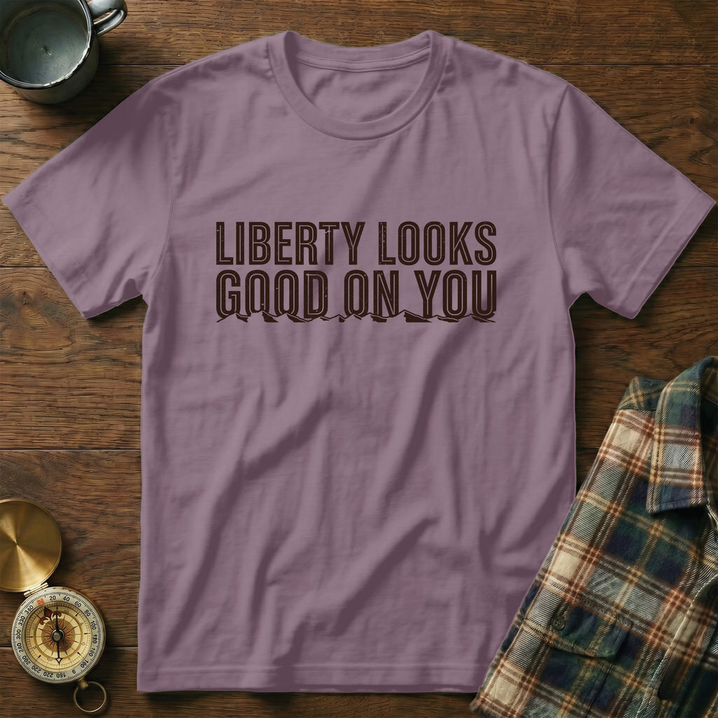 Purple t-shirt with "LIBERTY LOOKS GOOD ON YOU" text and mountain graphic.