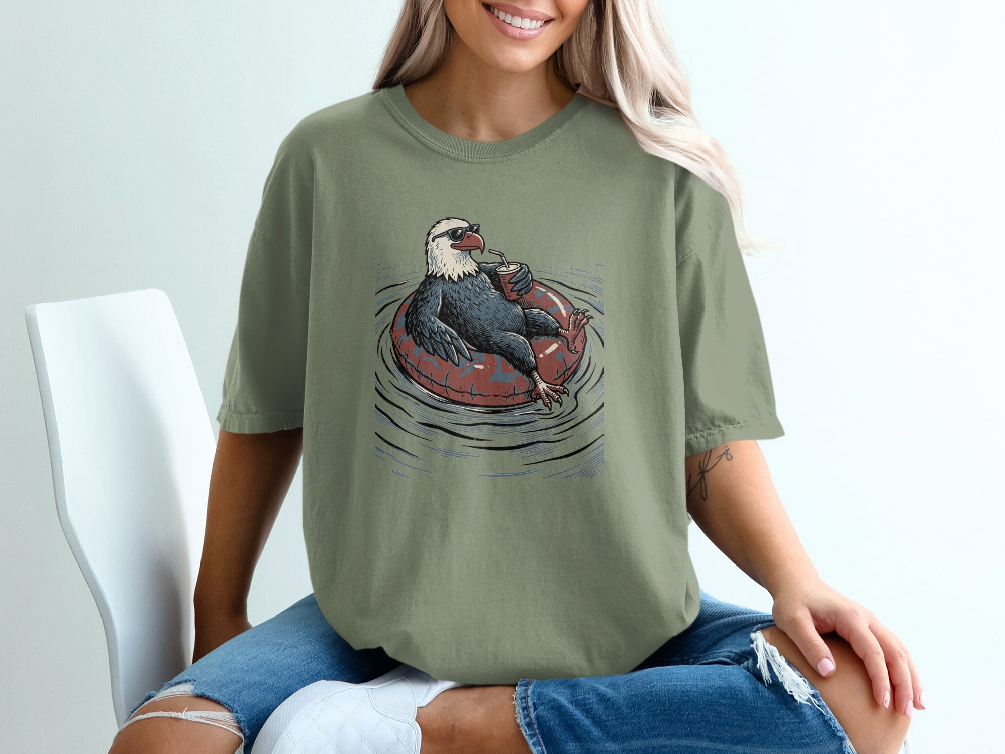 Bald eagle wearing sunglasses and floating in a tube with a drink.