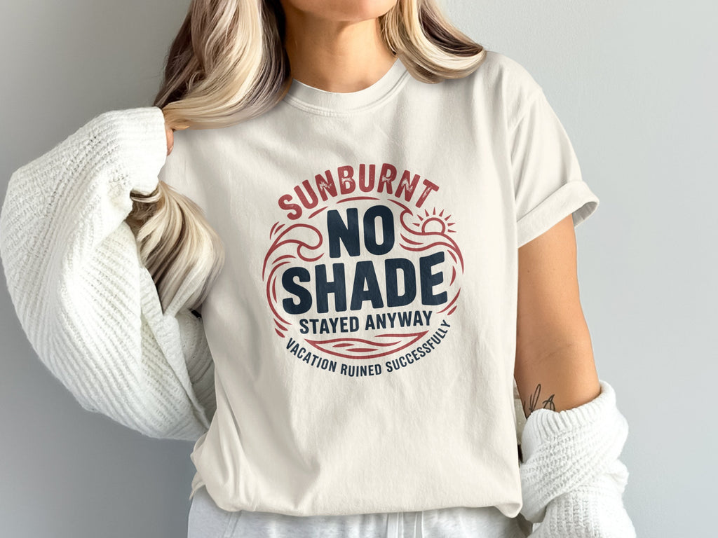 Cream t-shirt with red and blue text: "SUNBURNT NO SHADE STAYED AWAY VACATION RUINED SUCCESSFULLY".