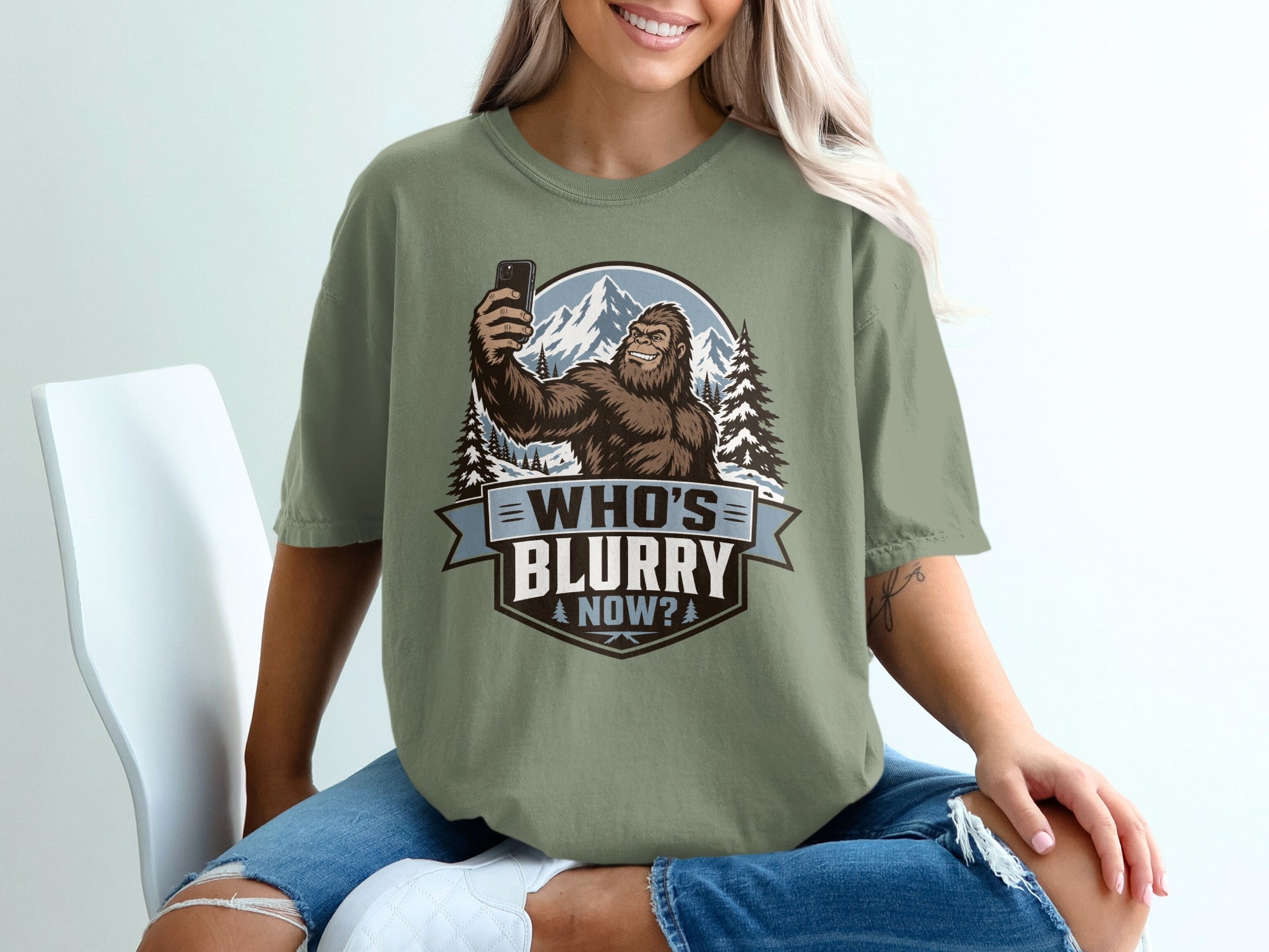 Bigfoot taking a selfie in front of mountains, text reads "WHO'S BLURRY NOW?"