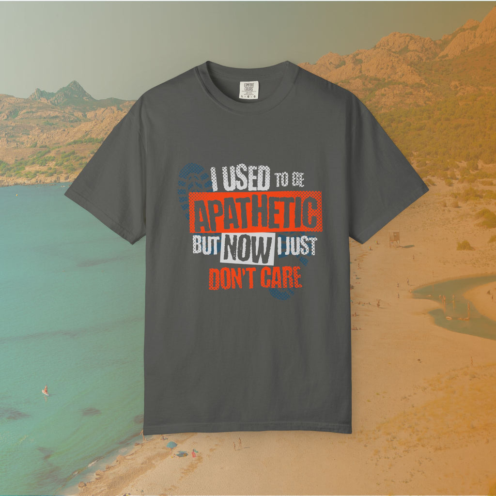 grey Graphic T-shirt featuring the layered, distressed text: "I USED TO BE APATHETIC BUT NOW I JUST DON'T CARE," overlaid with halftone dot textures and boot print graphics.