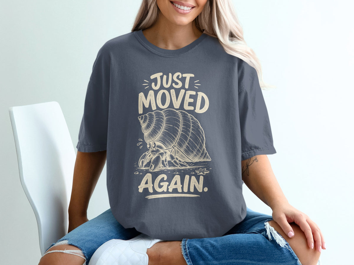 Dark gray t-shirt with "JUST MOVED AGAIN" and a hermit crab graphic.