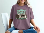 Crab with sunglasses and text "SIDEWAYS BY CHOICE" on a purple shirt.