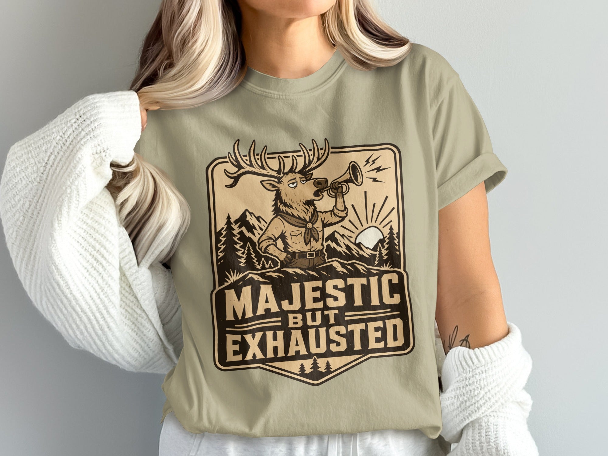 T-shirt graphic: Majestic but exhausted deer blowing a horn in mountains.