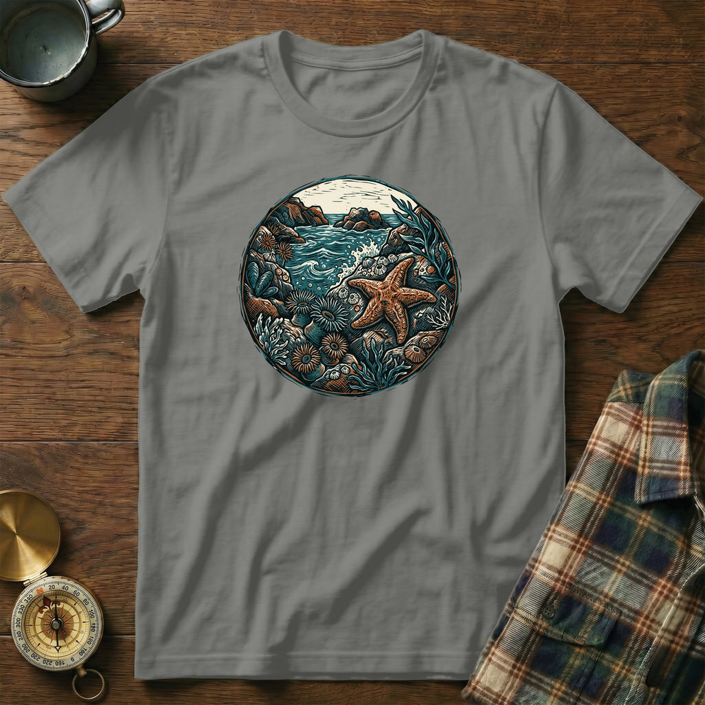 Circular graphic of a starfish and ocean life on a grey t-shirt.