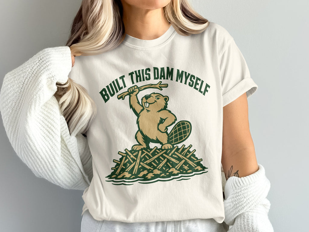 Beaver on a dam of sticks, text "BUILT THIS DAM MYSELF"