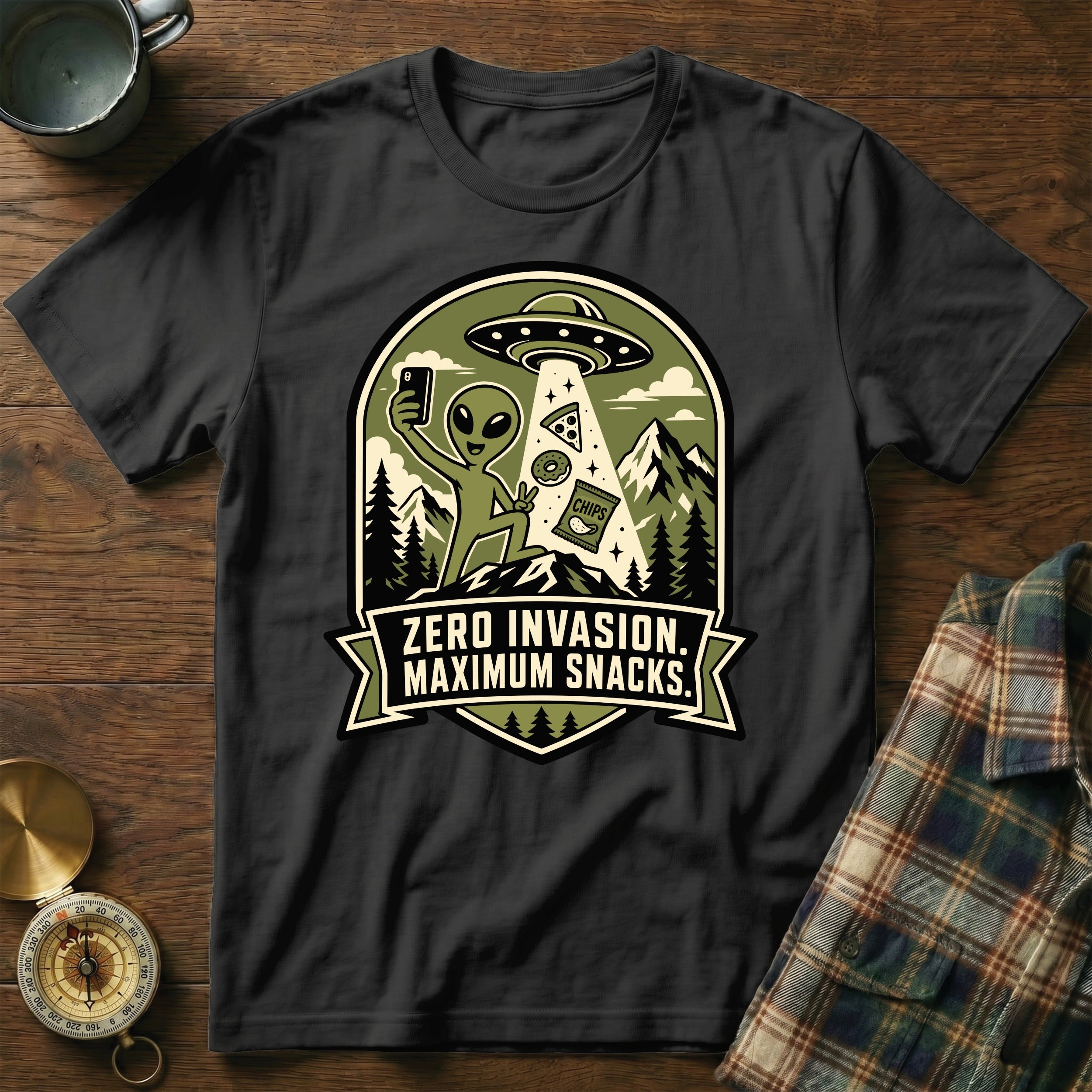 Green, white, and black graphic on black shirt with alien, UFO, and snacks.