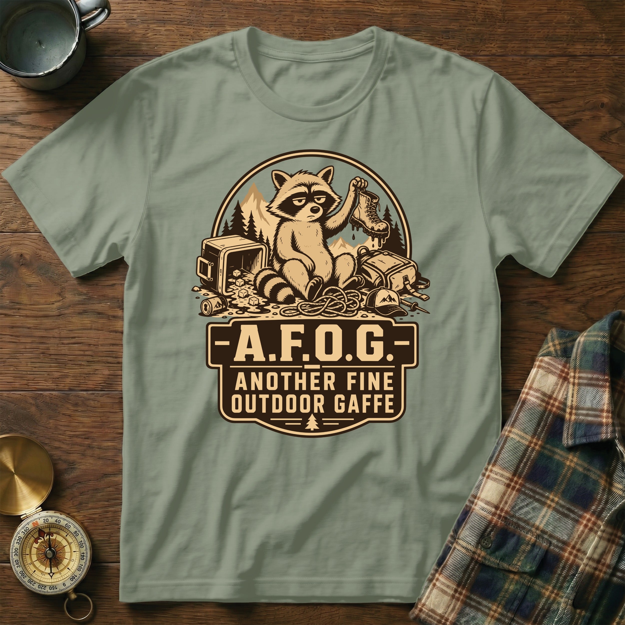 Green t-shirt with a raccoon graphic and text "-A.F.O.G.- ANOTHER FINE OUTDOOR GAFFE".