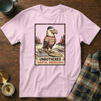 Eagle wearing a hat and striped shirt, surfing on a surfboard, with text "UNBOTHERED COASTAL AMERICANA".
