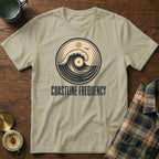 Light tan t-shirt with circular wave and vinyl graphic. COASTLINE FREQUENCY text.