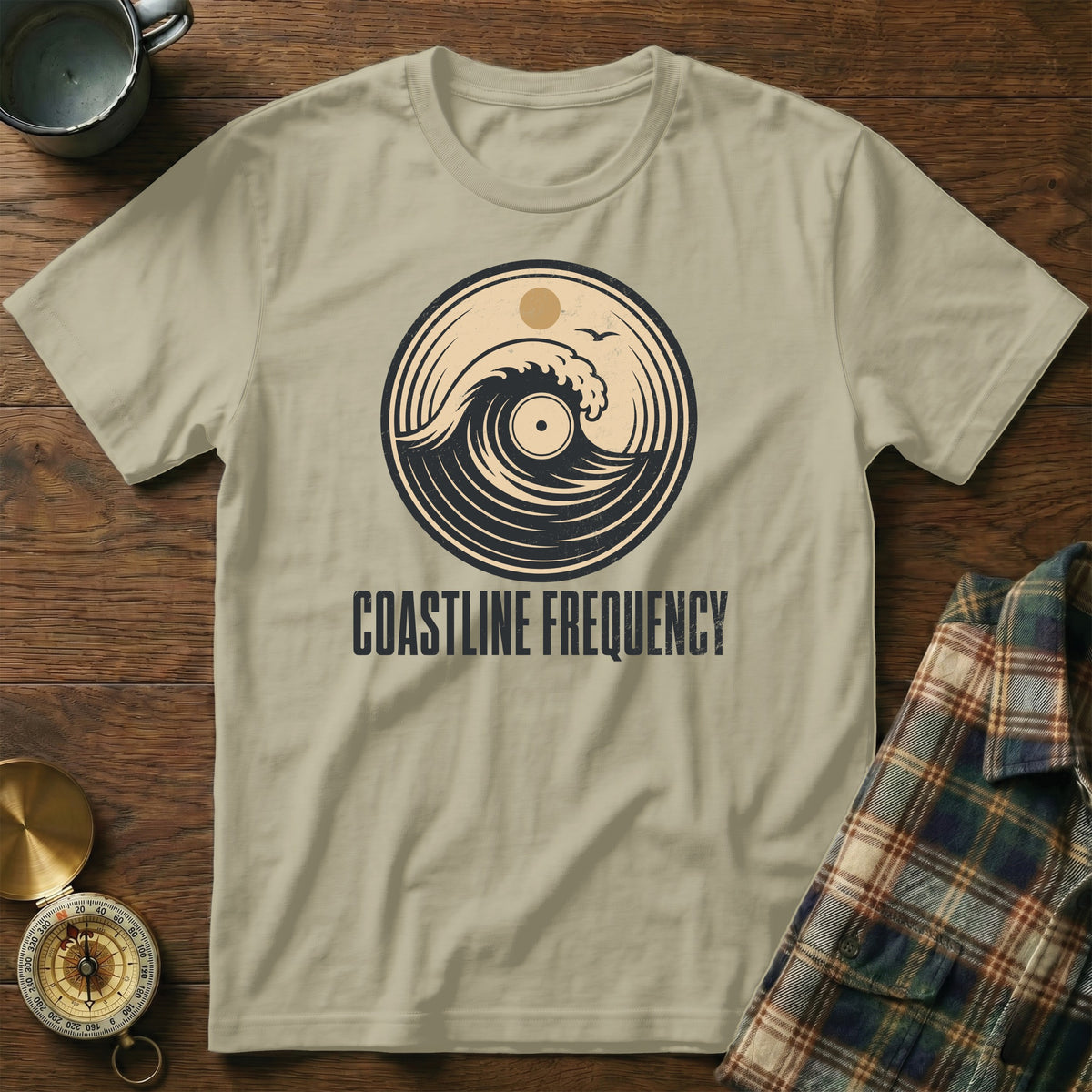 Light tan t-shirt with circular wave and vinyl graphic. COASTLINE FREQUENCY text.