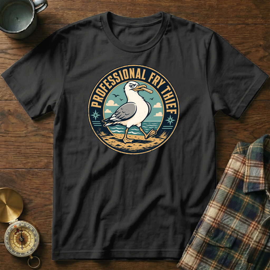 Black t-shirt with "Professional Fry Thief" text and a seagull graphic on a beach.