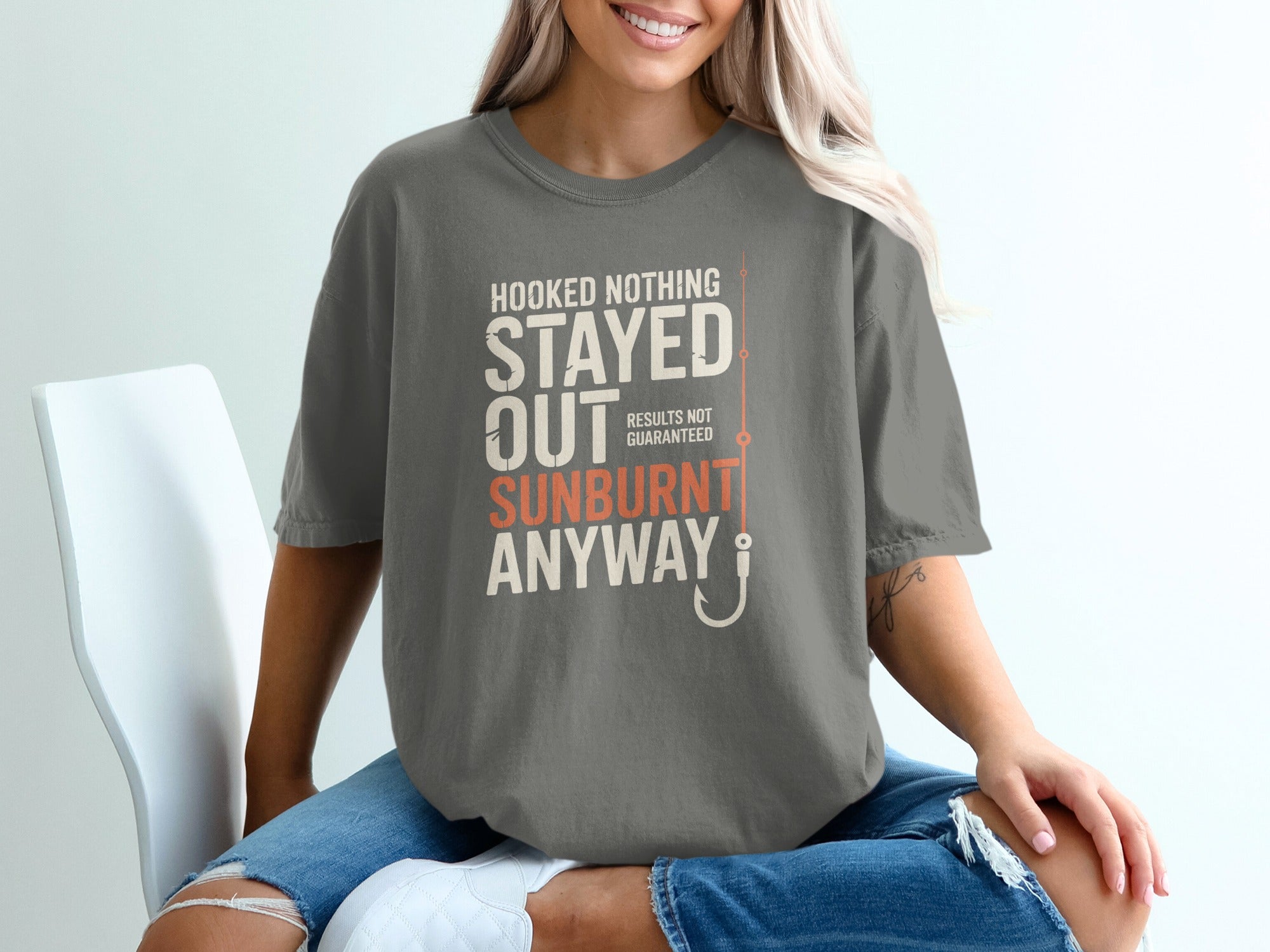 Gray t-shirt with text "Hooked Nothing Stayed Out Sunburn" and a fishing hook.