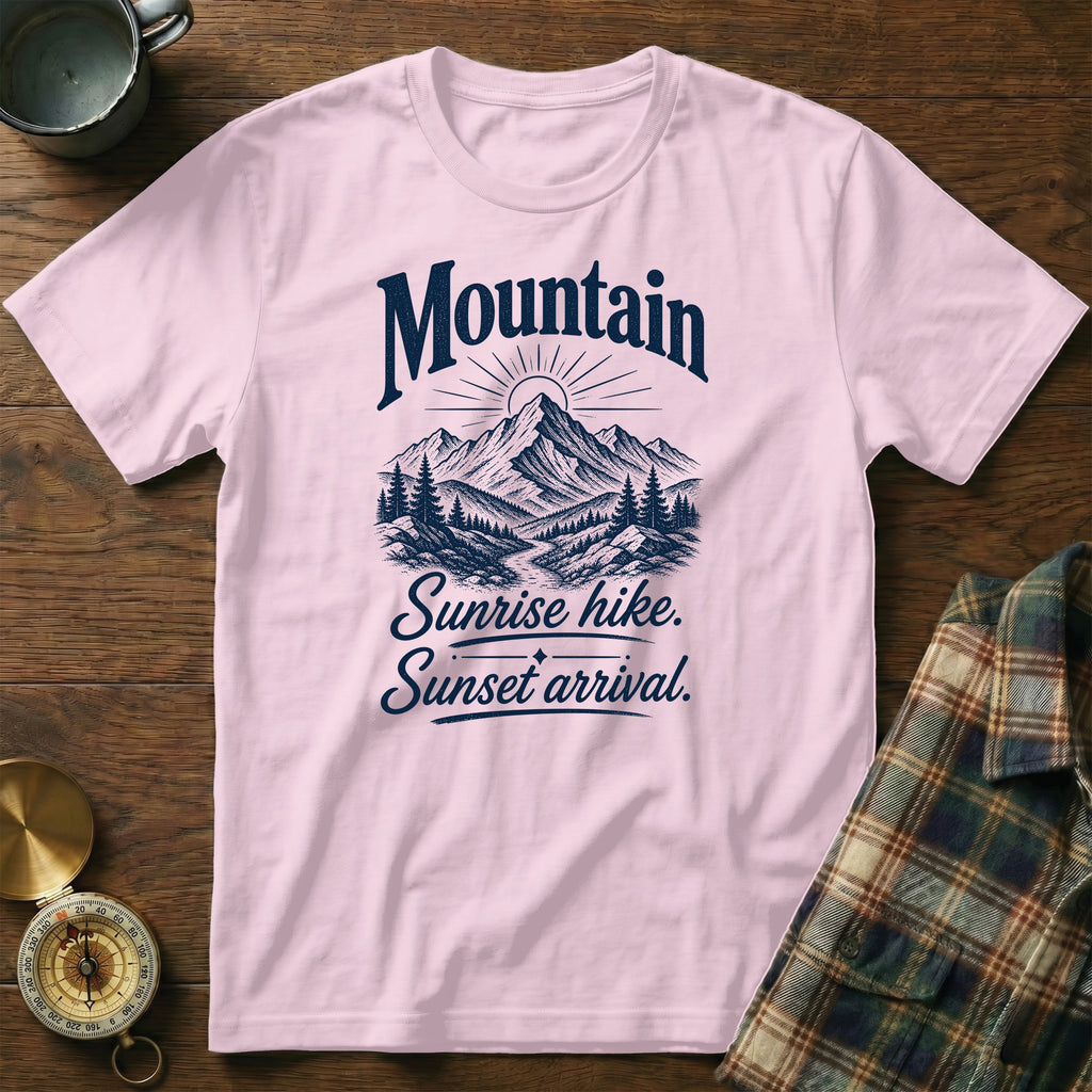 Light pink t-shirt featuring a navy mountain graphic and text reading Mountain Sunrise hike. Sunset arrival.