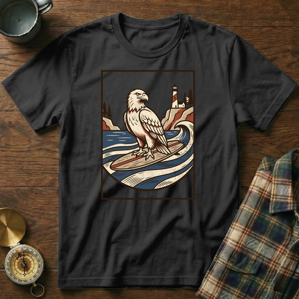 Black t-shirt with a graphic of an eagle surfing with a lighthouse in the background.