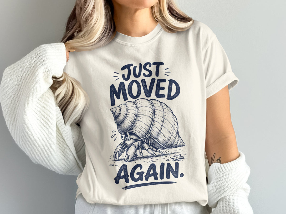 Hermit crab graphic on a cream t-shirt with text "Just Moved Again".