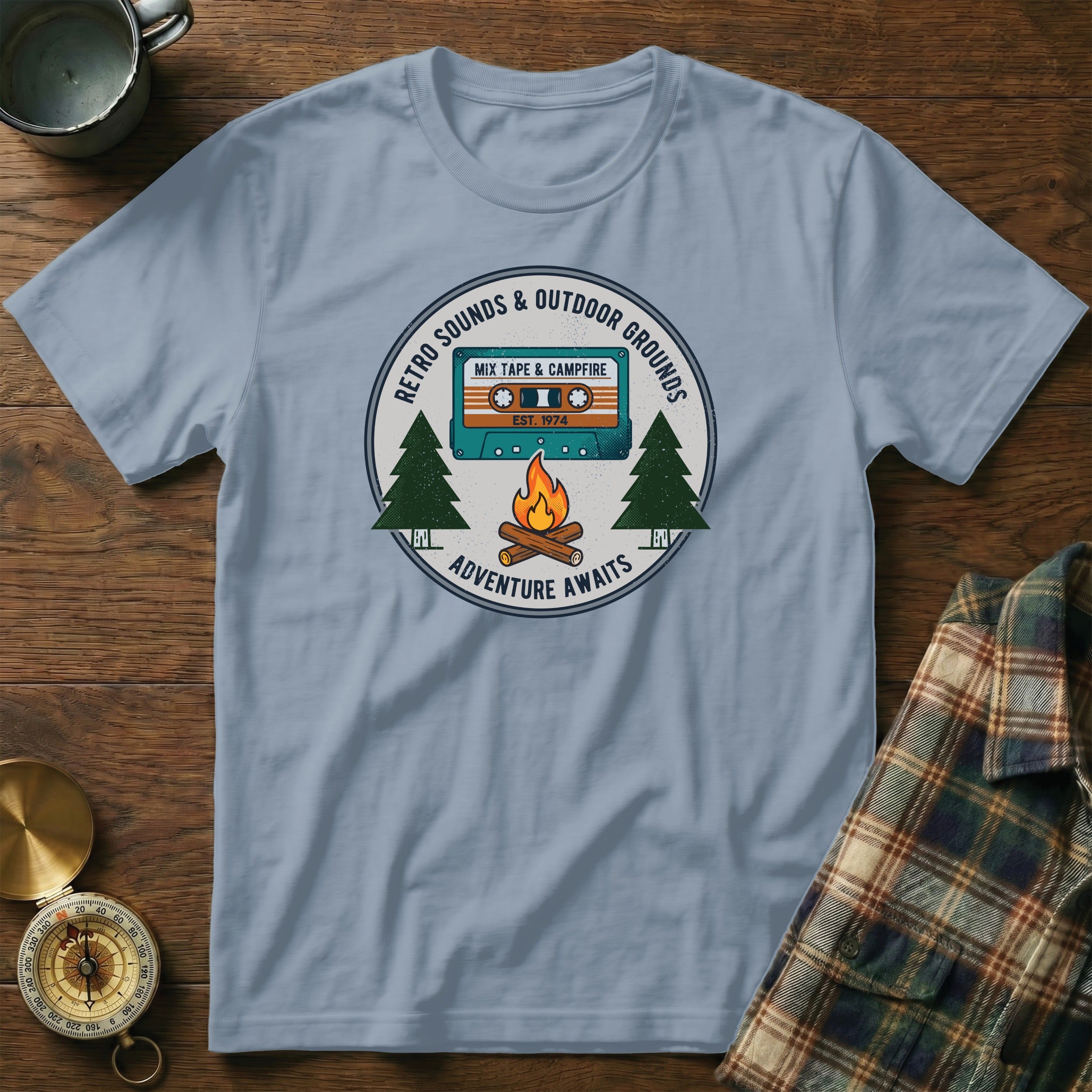 Light blue t-shirt with retro cassette tape, campfire, and trees graphic.