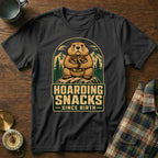 Black t-shirt with a groundhog holding nuts and text "Hoarding Snacks Since Birth".