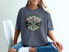 T-shirt with circular mountain, pine trees, and lake graphic.