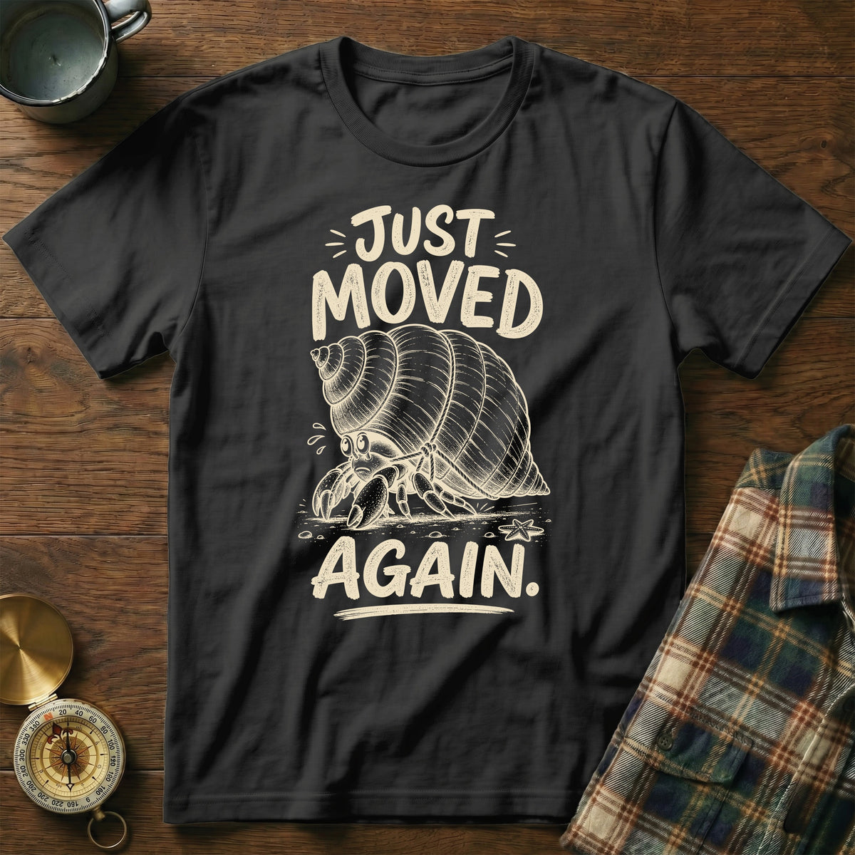 Black t-shirt with hermit crab graphic and text "JUST MOVED AGAIN."