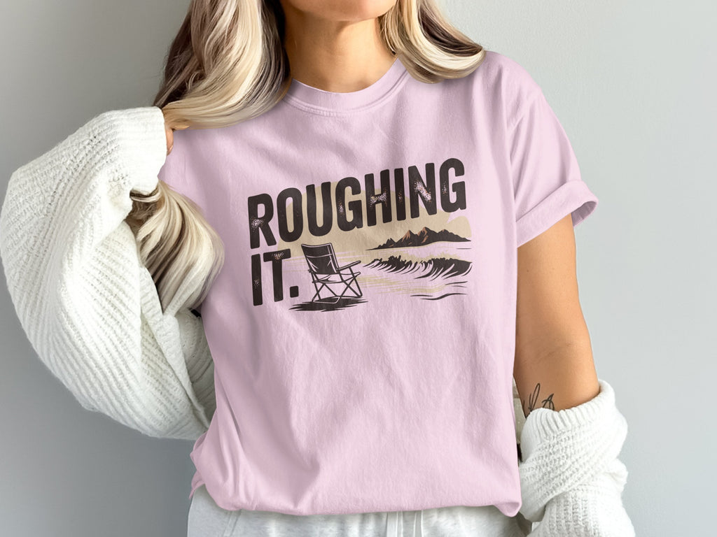 Pink t-shirt with "ROUGHING IT" text and beach scene graphic.