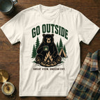 A white t-shirt with a graphic of a bear by a campfire, reading "Go Outside Great View. Unclear Exit."