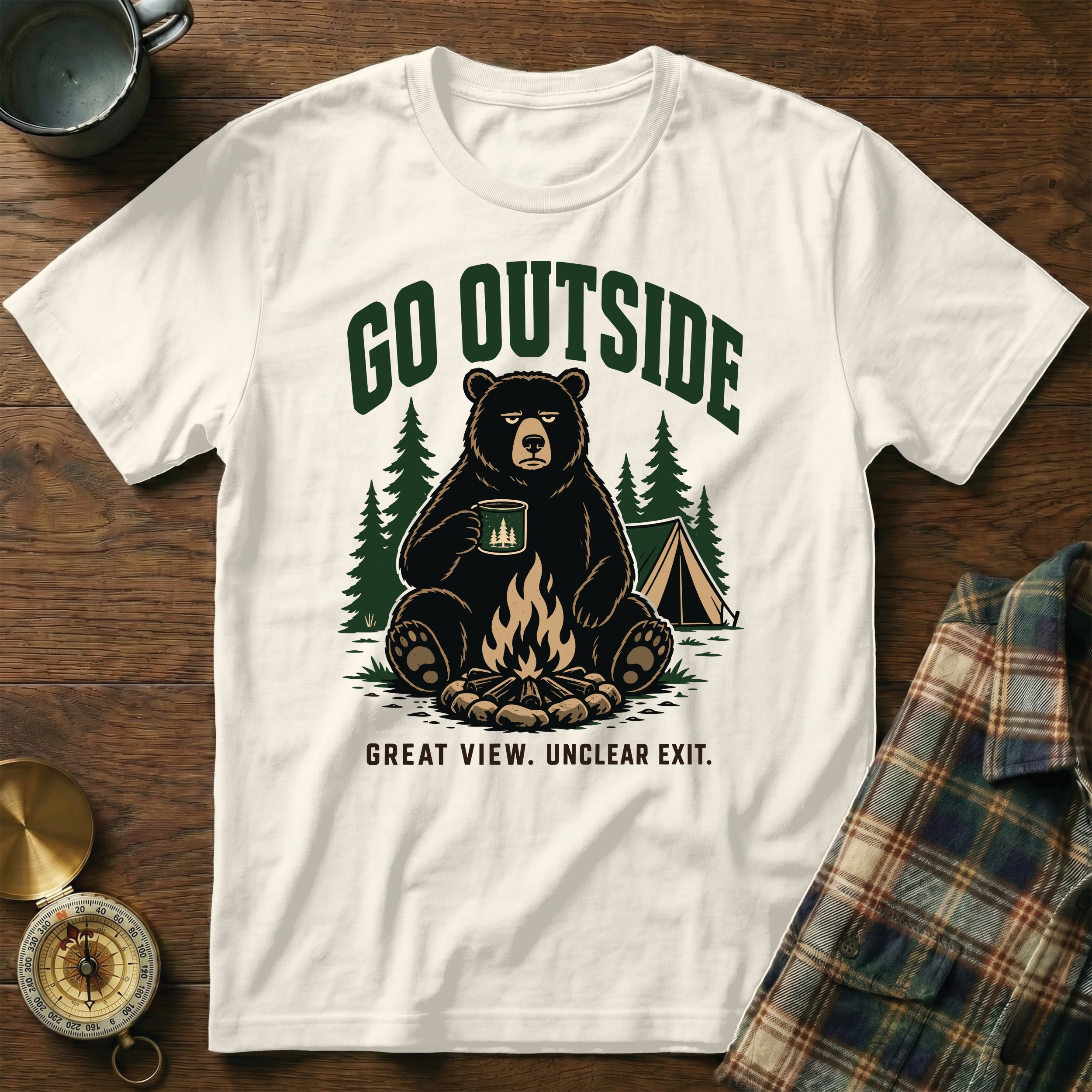A white t-shirt with a graphic of a bear by a campfire, reading "Go Outside Great View. Unclear Exit."